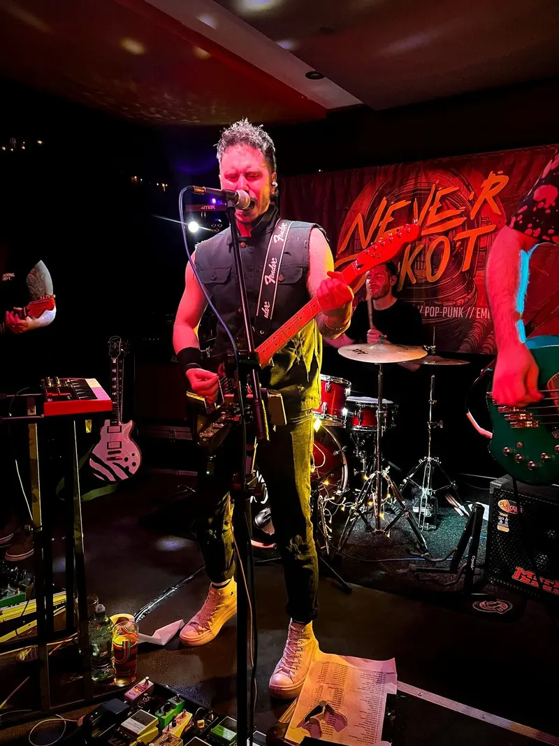 Never Dakota's singer mid-song, with the band's banner glowing behind